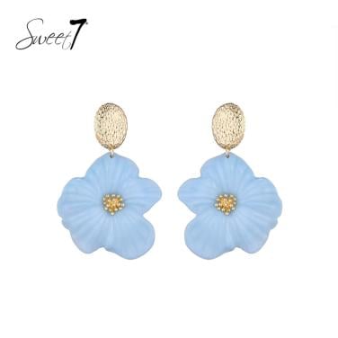 Oorbellen met blauwe bloemen en goudkleurige accenten.