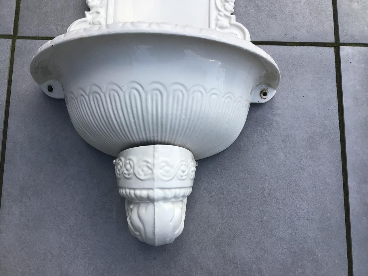 Gietijzeren wandlantaarn en fontein