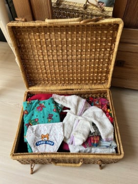 Mandje vol met poppenkleertjes