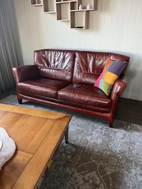Lederen bank met stoelen en poef