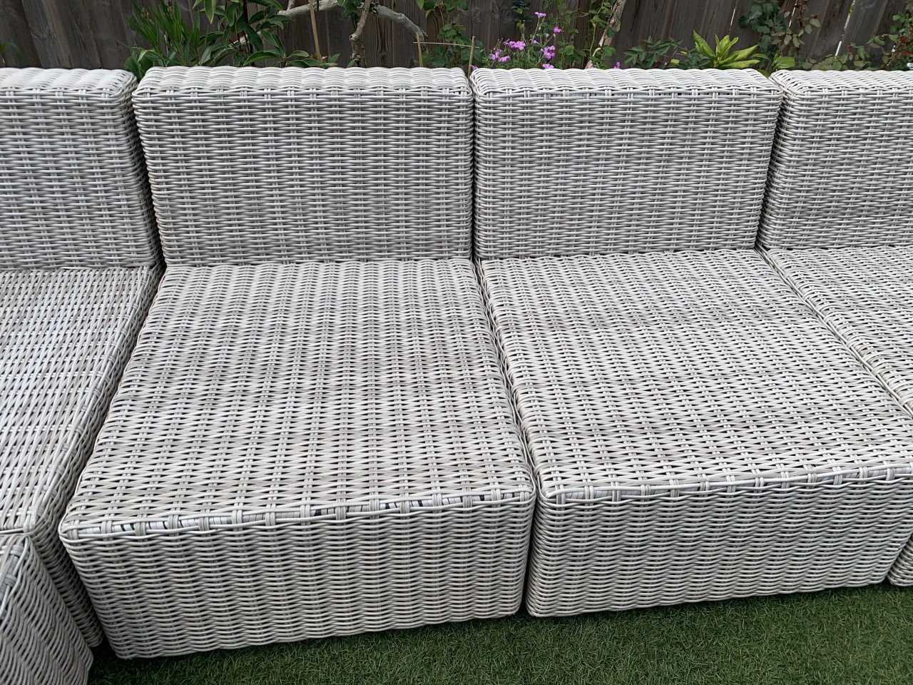 Rieten loungeset met kussens en tafel.