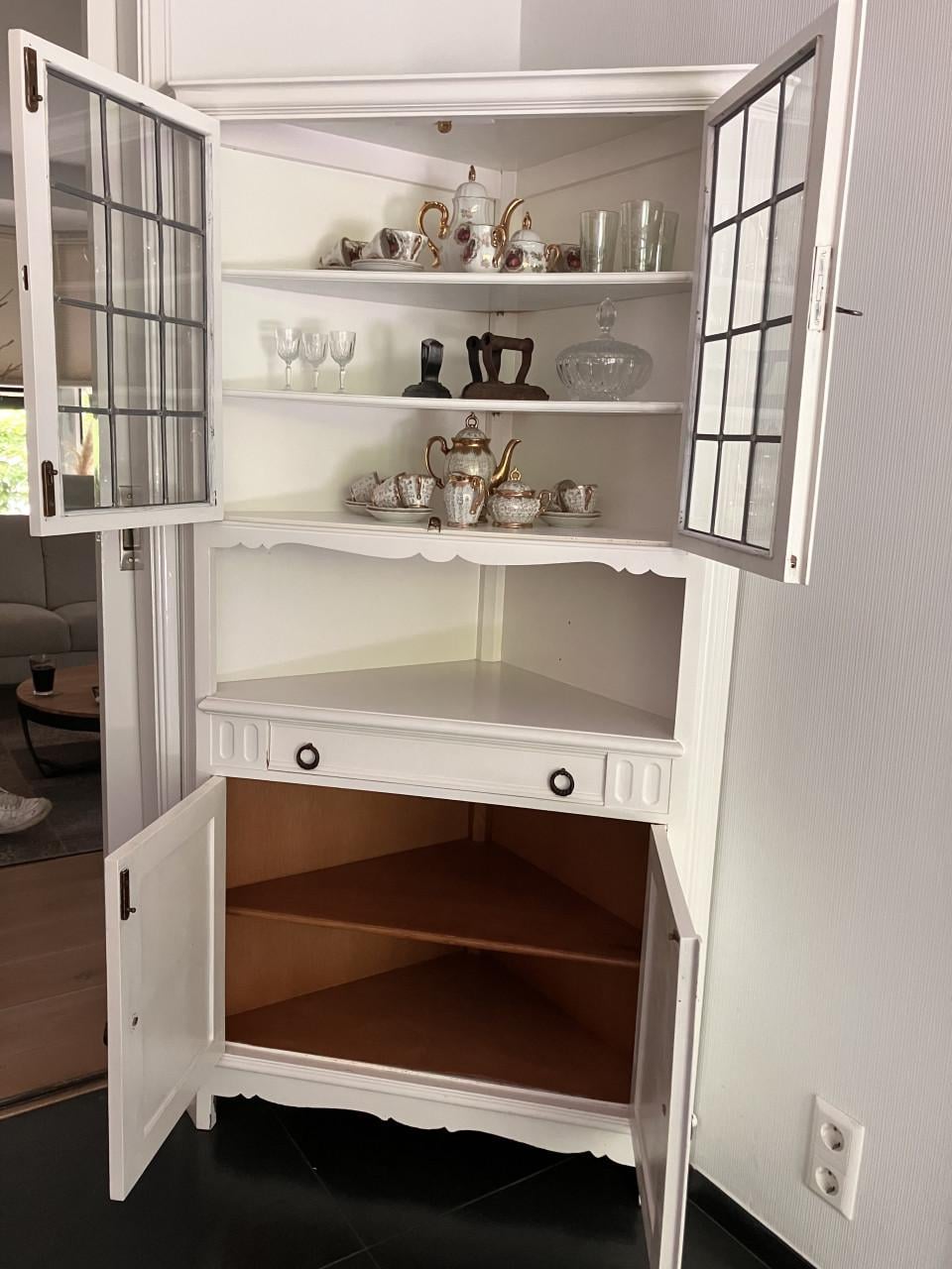Witte hoekkast met glas-in-lood details