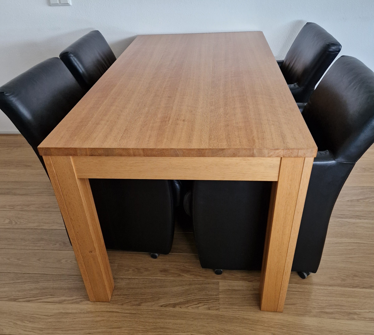 Eethoek met 4 leren stoelen op wieltjes