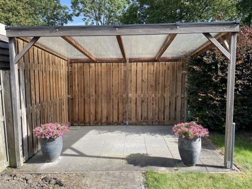Vrijstaande overkapping (hout met aluminium/polycarbonaat dak)