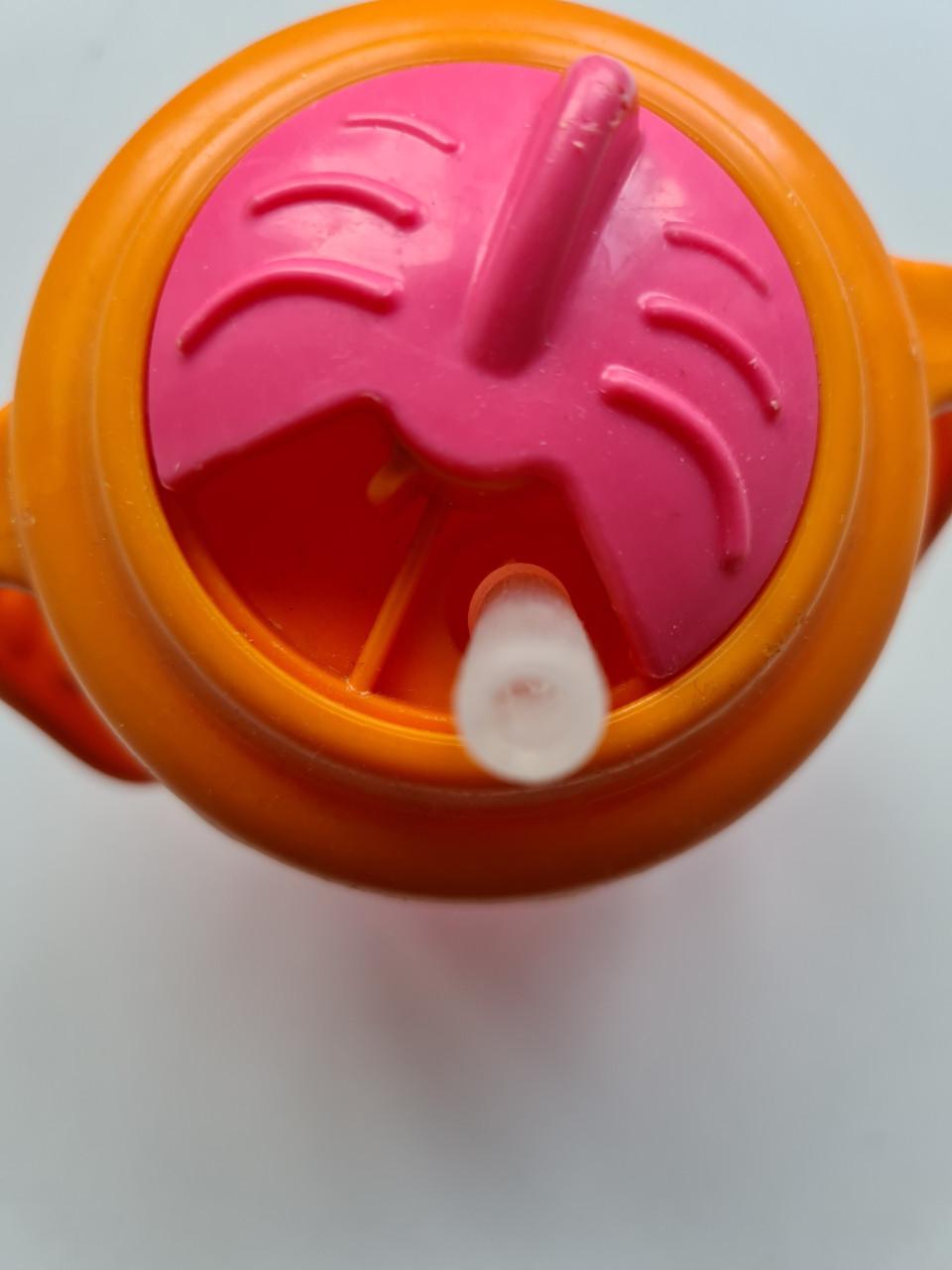 Munchkin Tip & Sip rietjesbeker met oranje deksel en roze beker.
