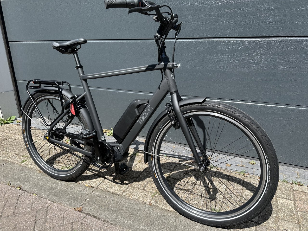 Sportieve elektrische herenfiets middenmotor en riem aandrijving