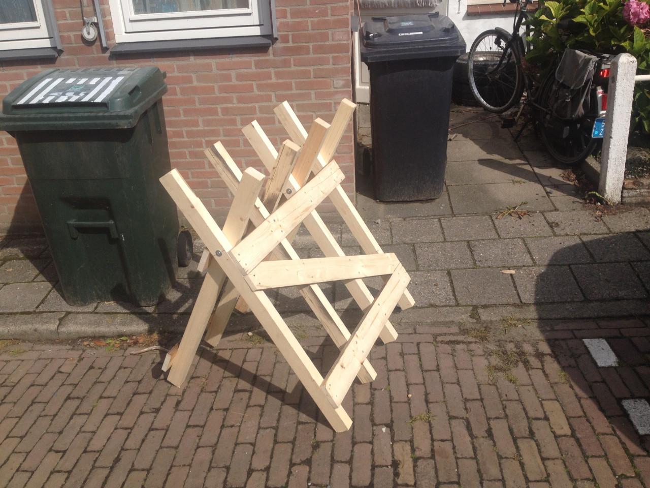 Rechtop hout doorzagen  met kettingzaag en robuste zaagbok als werkbank