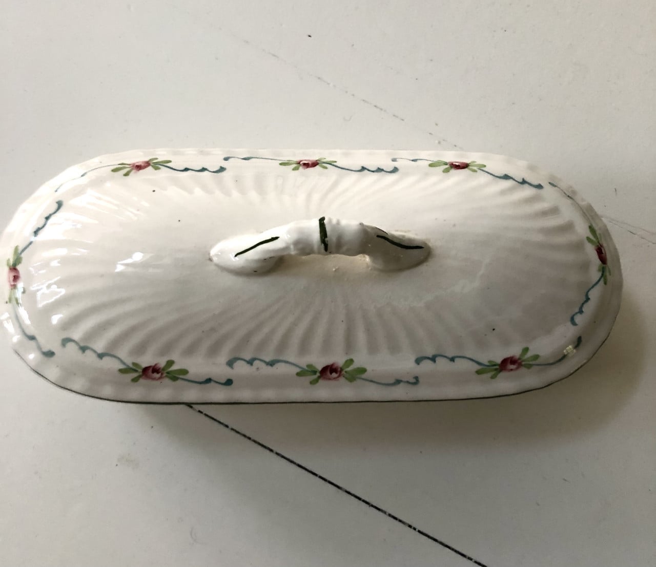 Lief brocante theelepelbakje van wit porselein met motiefje.