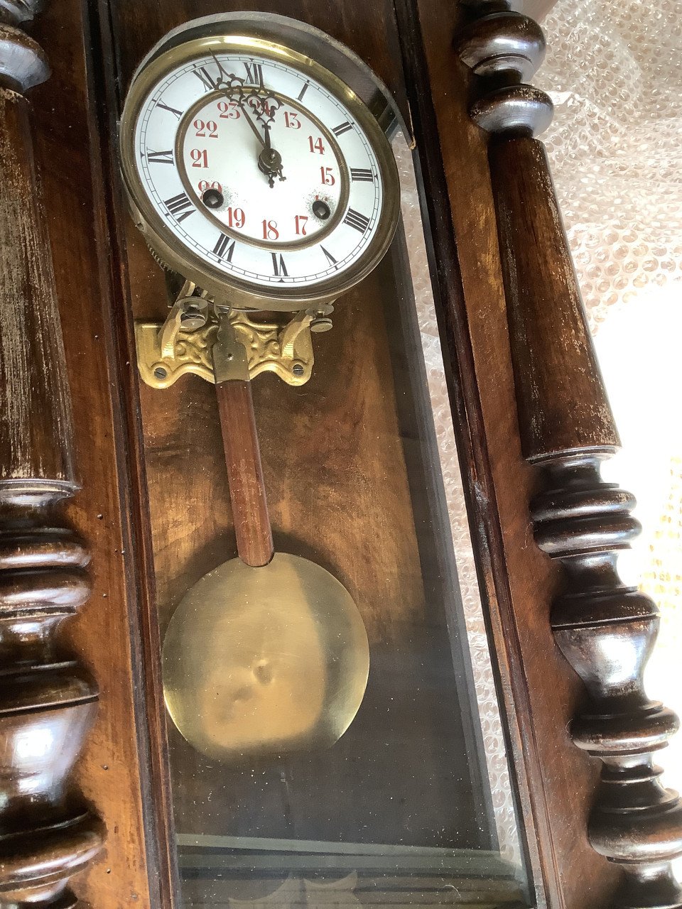 Oude, vintage hangklok met slinger en sleutel.