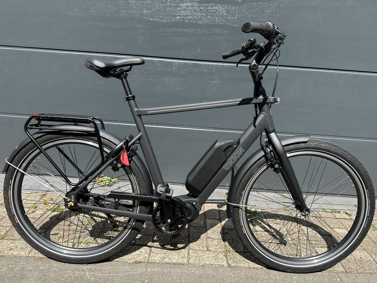 Sportieve elektrische herenfiets middenmotor en riem aandrijving