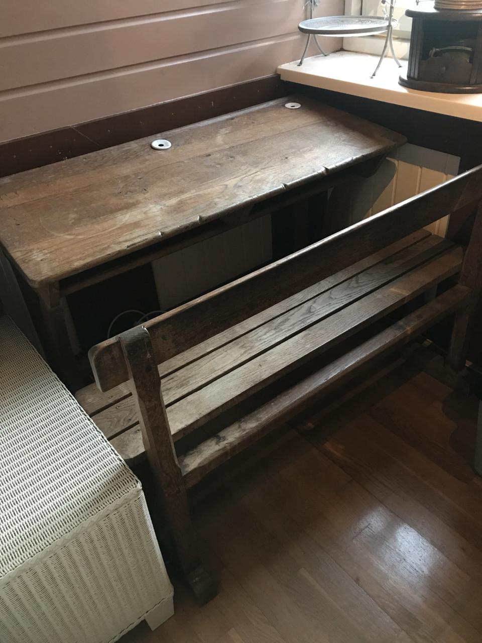 Oude schoolbank met porseleinen inktpotjes