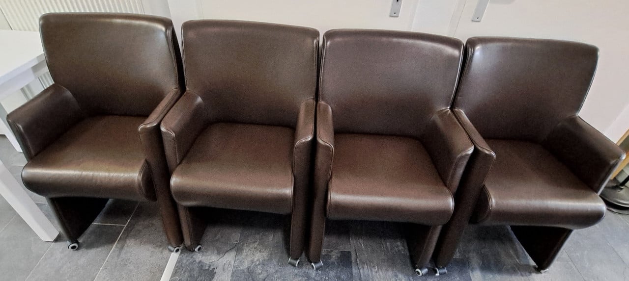 4 bruine kunstlederen stoelen op wieltjes