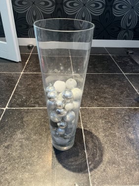 Kerstballen in grote glazen vaas