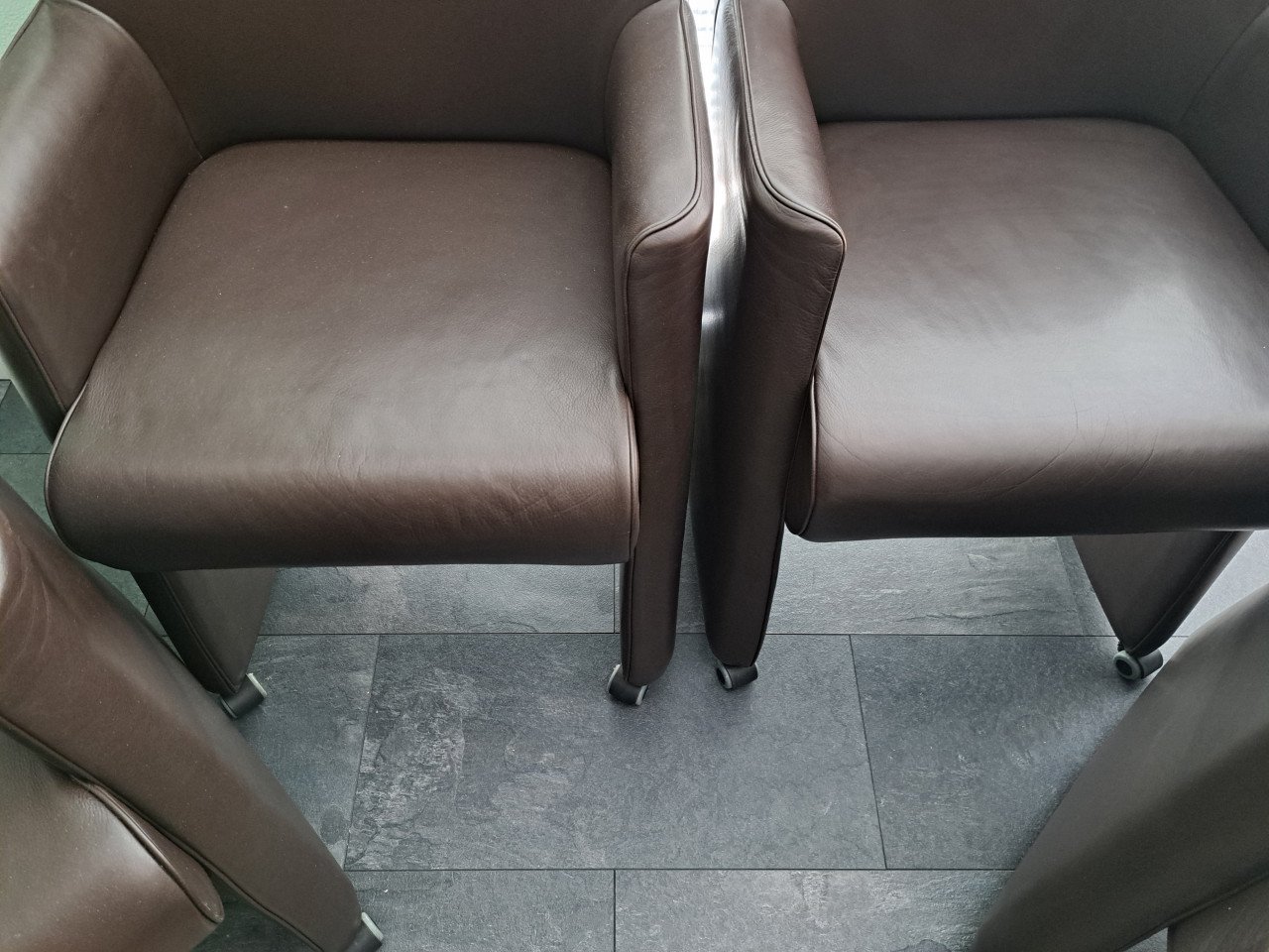 4 bruine kunstlederen stoelen op wieltjes