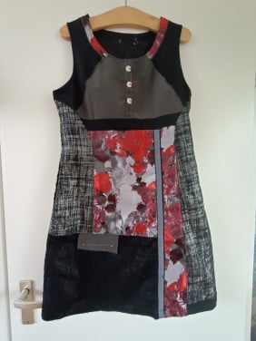 Leuke jurk. Kleuren rood, zwart, grijs. Maat 40. Lengte achterpand 86 cm.