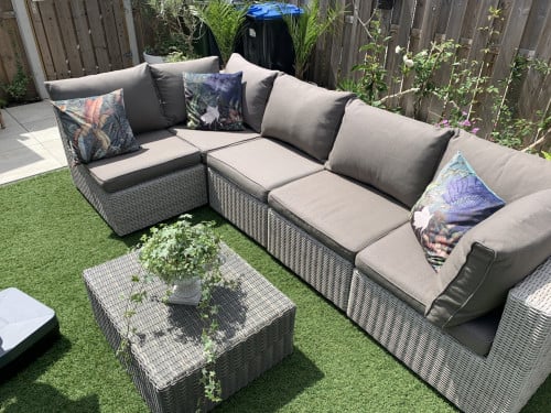 Rieten loungeset met kussens en tafel.