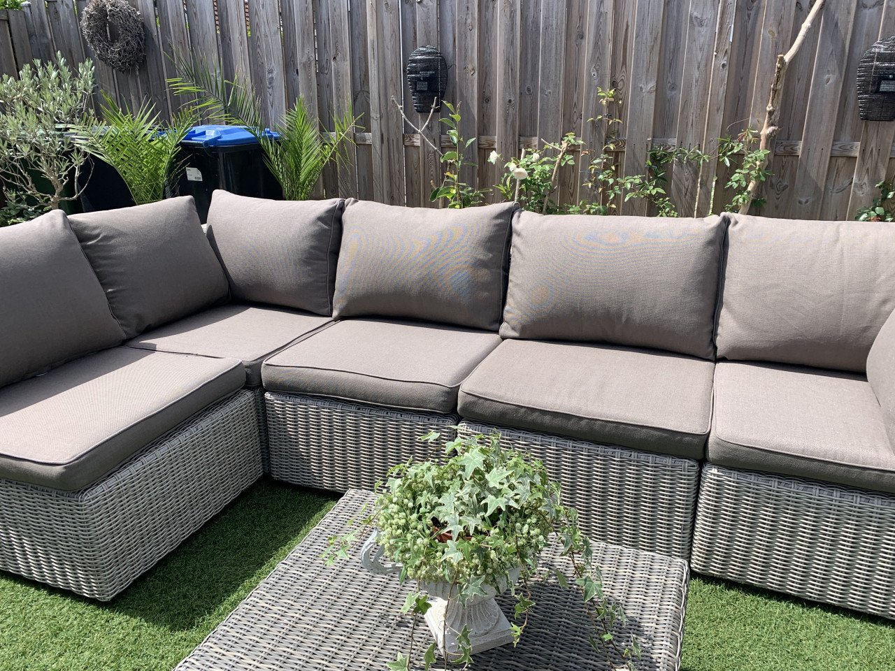 Rieten loungeset met kussens en tafel.