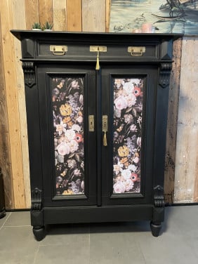 Stijlvol zwart Kastje met bloemenpanelen.
