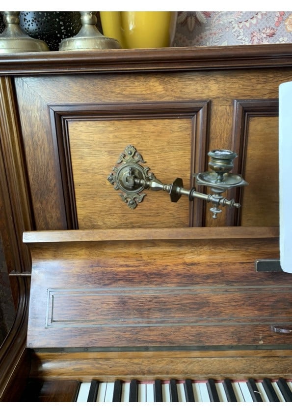 Oude bruine piano met kandelaren