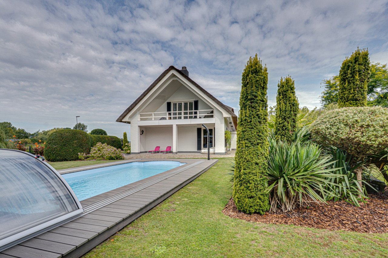 Rietgedekte villa met een overdekt zwembad.