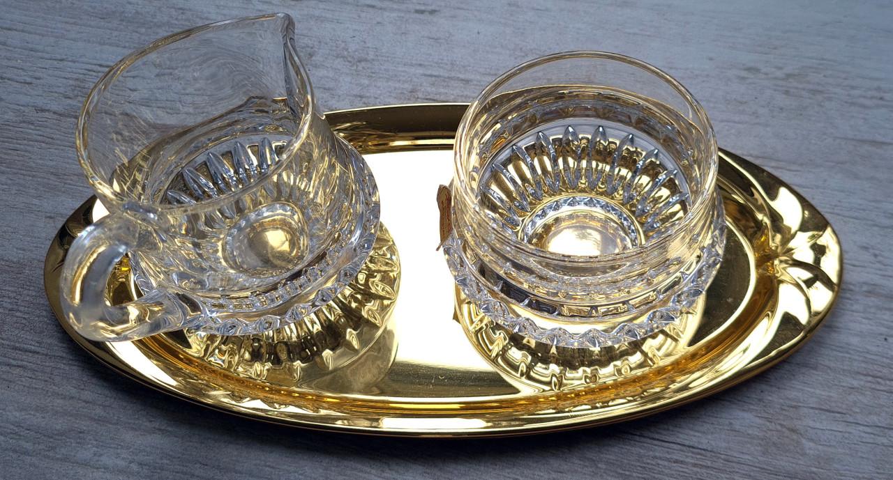 Kristallen melk en suikerset op goudschaal in oogverblindende staat