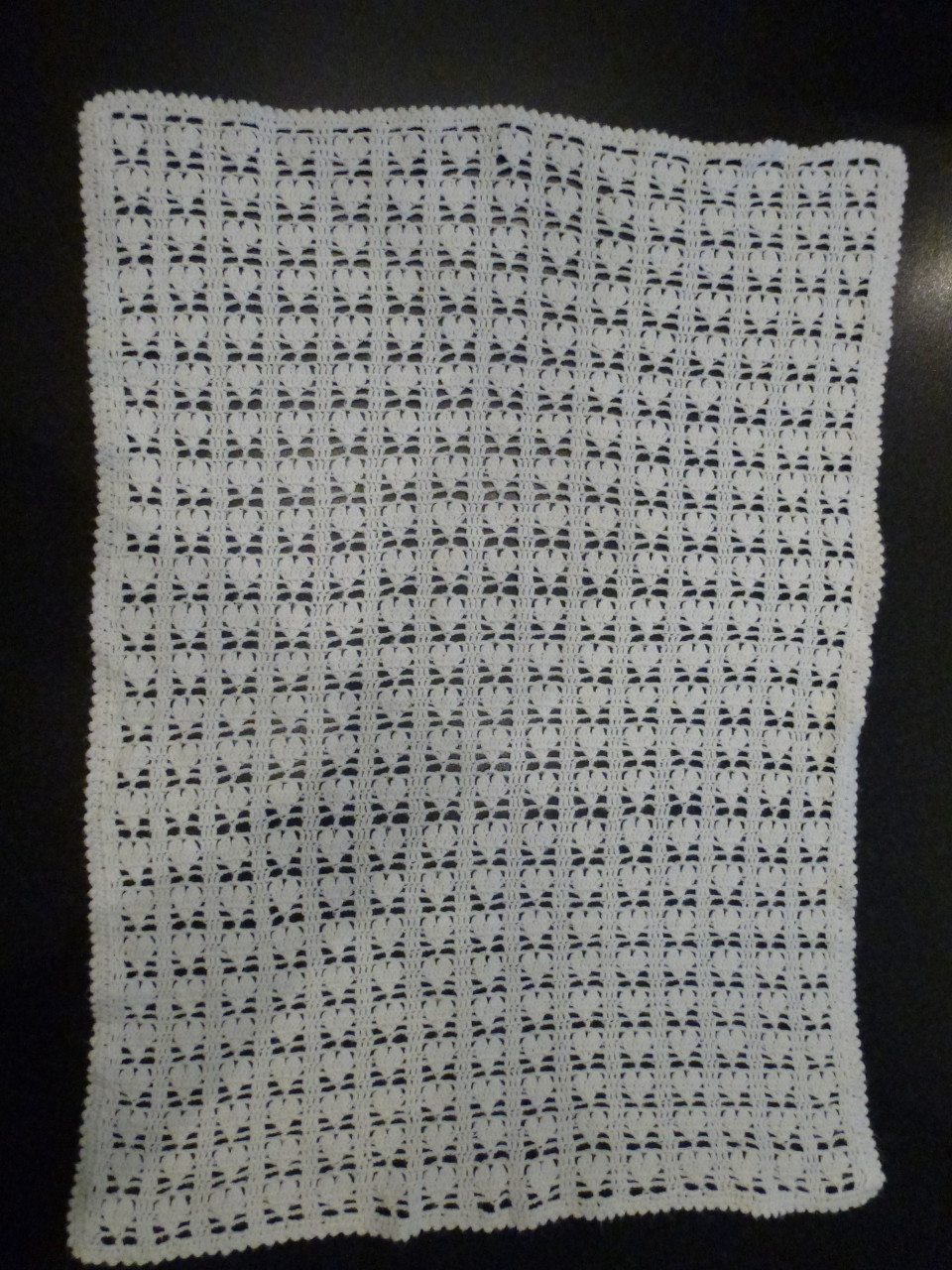 Wit gehaakte baby omslagdoek met hartjes.