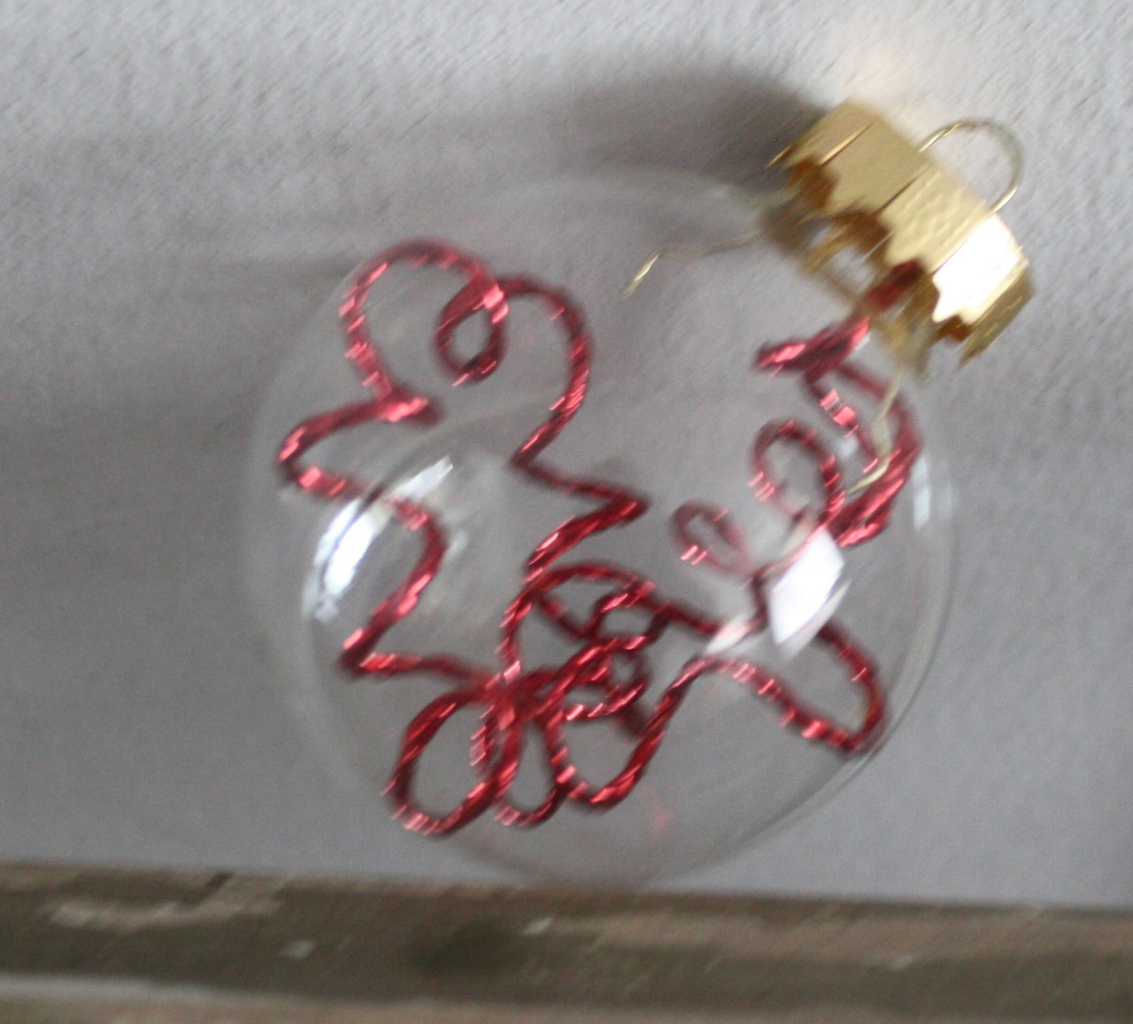 Kunststof kerstbal transarant met rode glitter decoratie