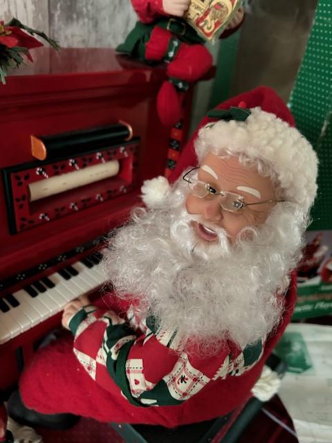 Holliday Creations bewegende kerstman speelt piano.