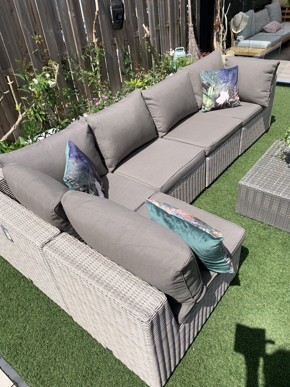 Rieten loungeset met kussens en tafel.