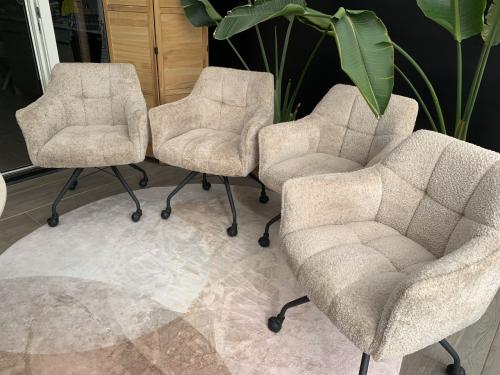 4 Eetkamerstoelen beige met wielen.