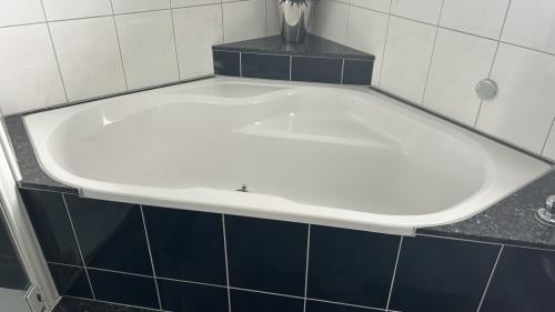 Bad, hoekopstelling, acryl, Grohe. Ligbad.