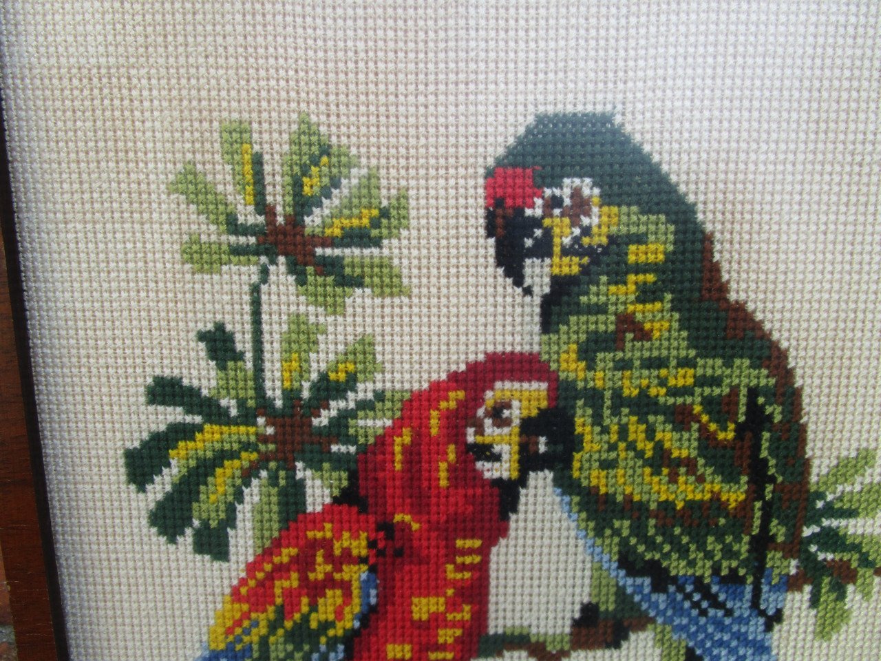2 geborduurde  papagaaien in gelijst achter ontspiegeld glas. 24 x 48 cm.