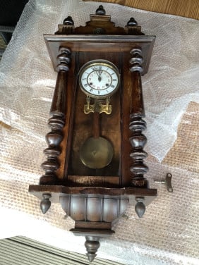 Oude, vintage hangklok met slinger en sleutel.