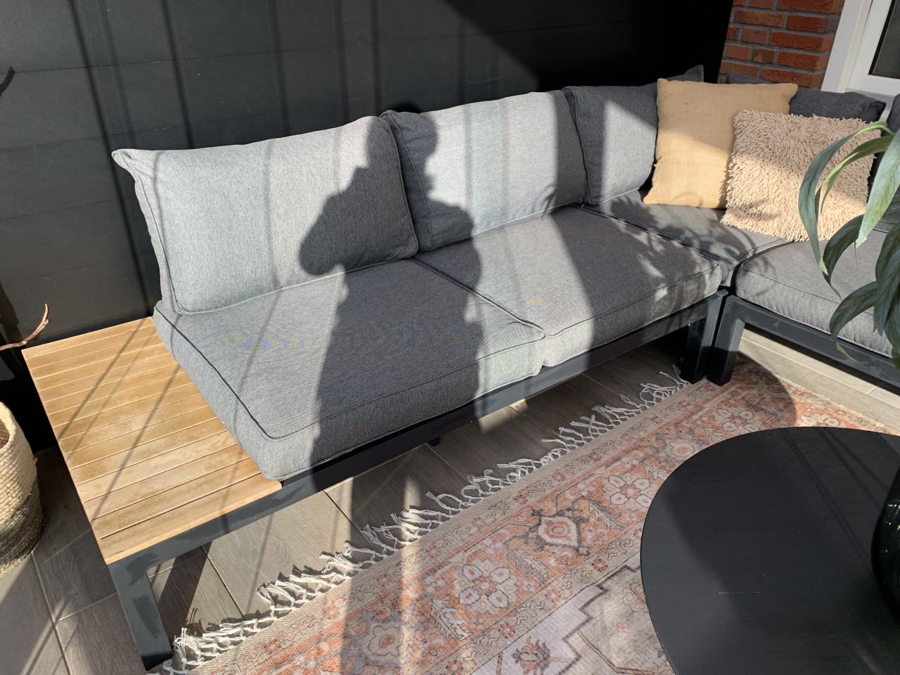 Zwarte loungset met houten plataus, kussens en tafel