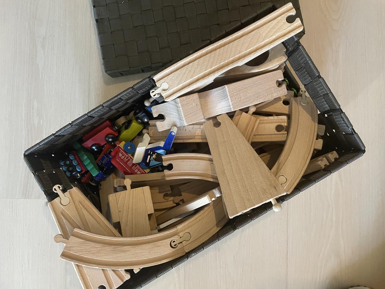 Grote mand vol houten treinrails en toebehoren