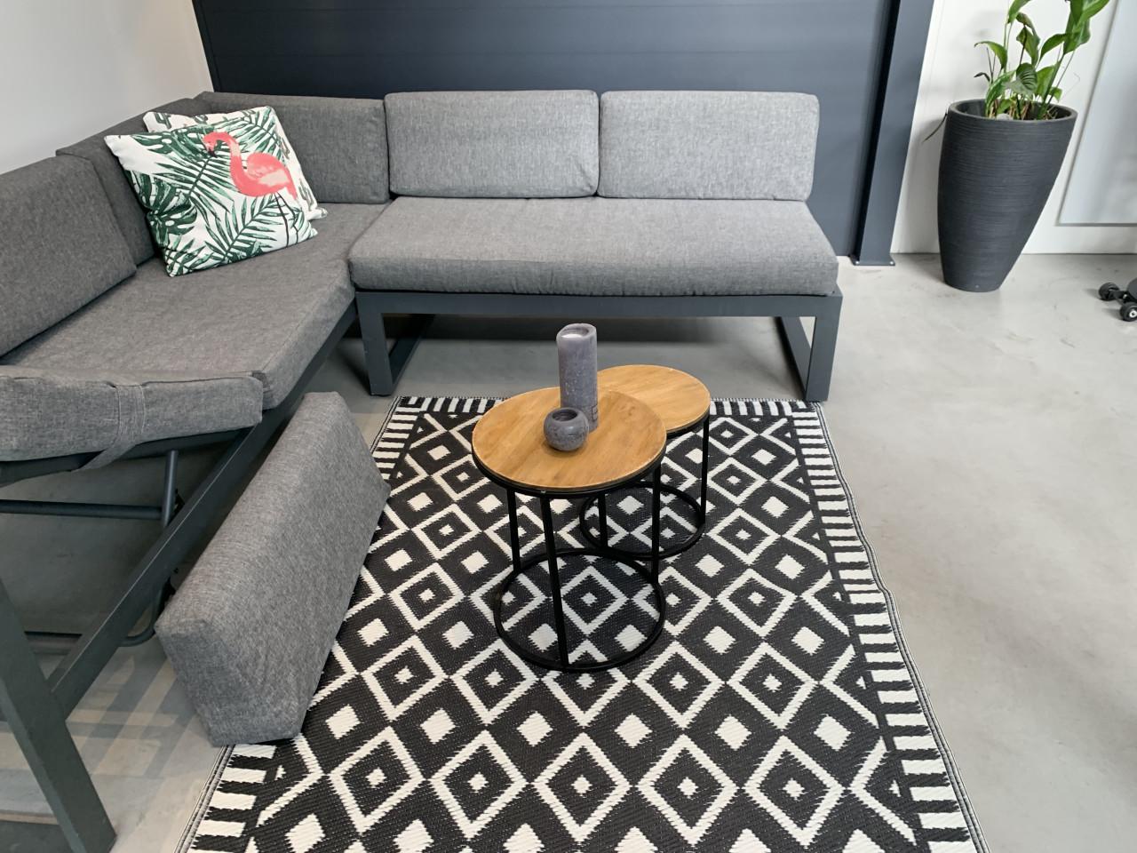 Loungeset aluminium grijs met grijze kussens en tafeltjes.