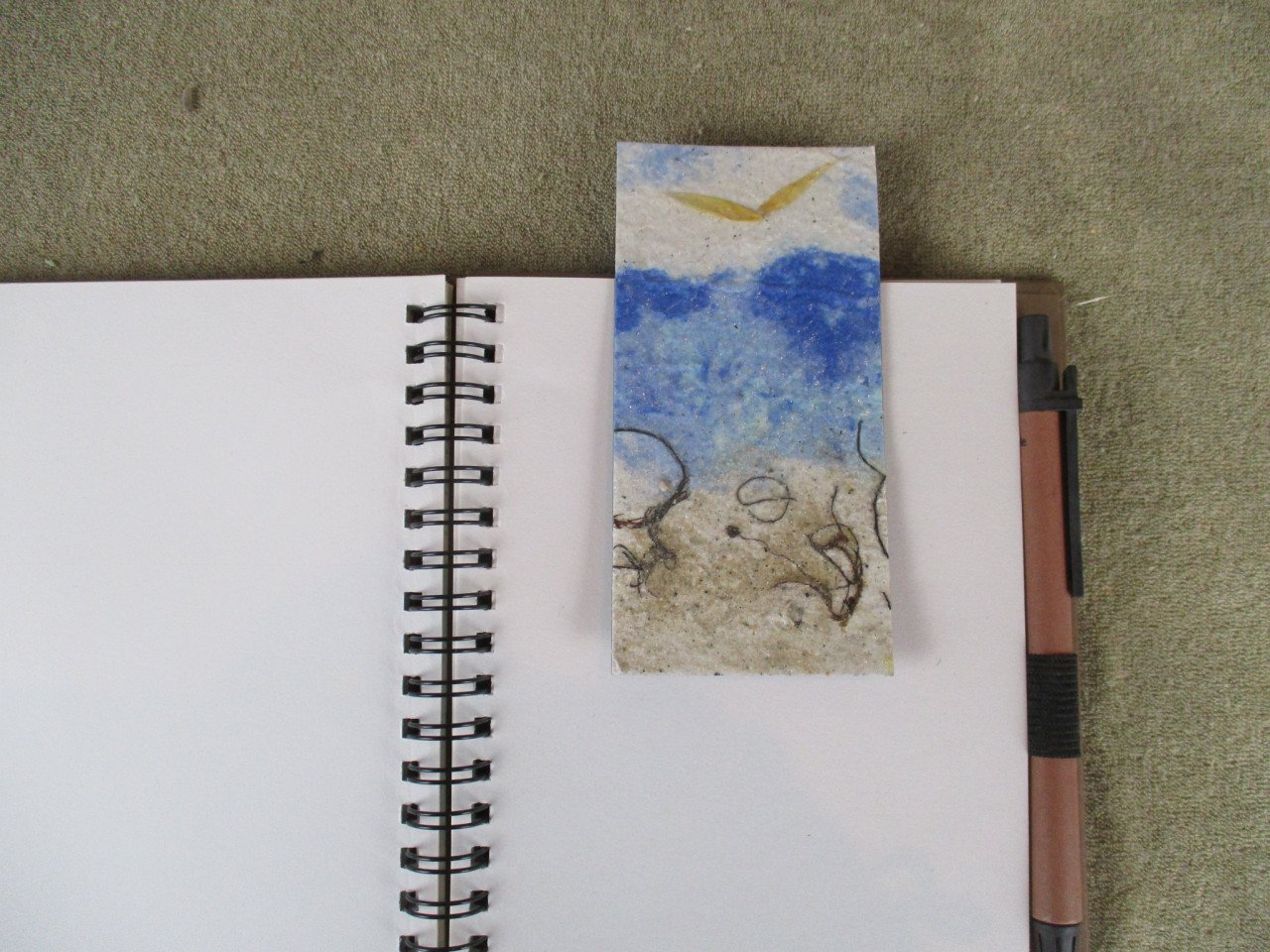 7 boekenleggers van handgeschept papier met thema zee en strand.