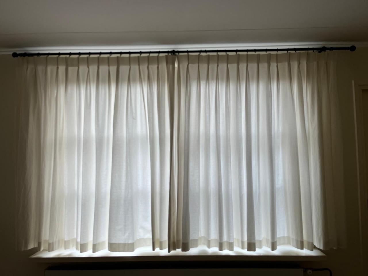 Mooie crèmekleurige gordijnen met zwarte roedes