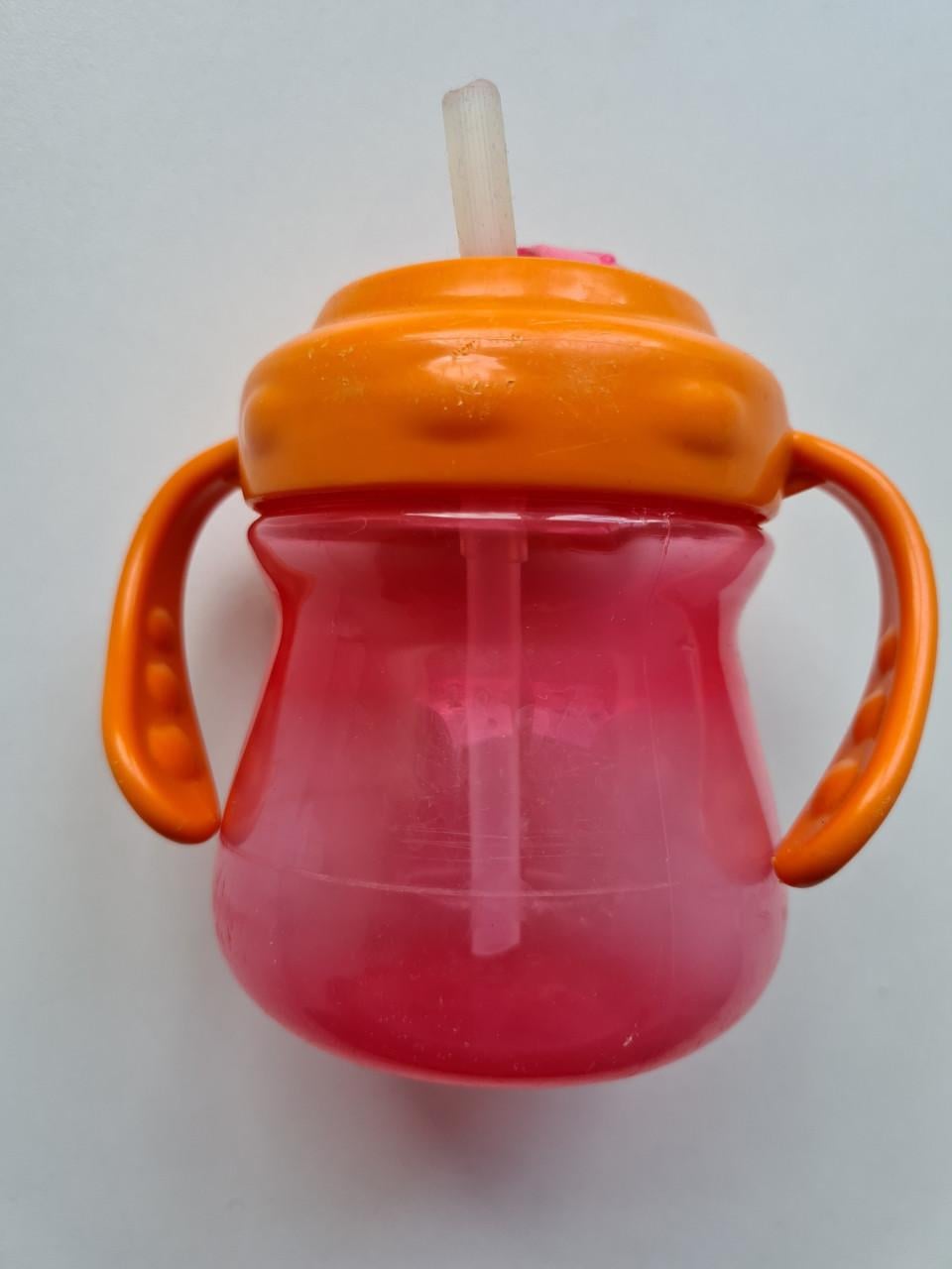 Munchkin Tip & Sip rietjesbeker met oranje deksel en roze beker.