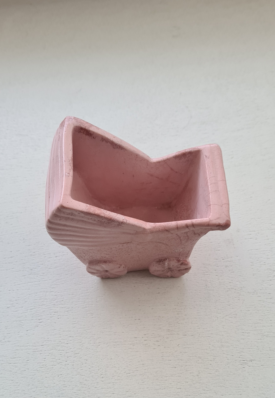 Schattig klein roze bloempotje in de vorm van een kinderwagen