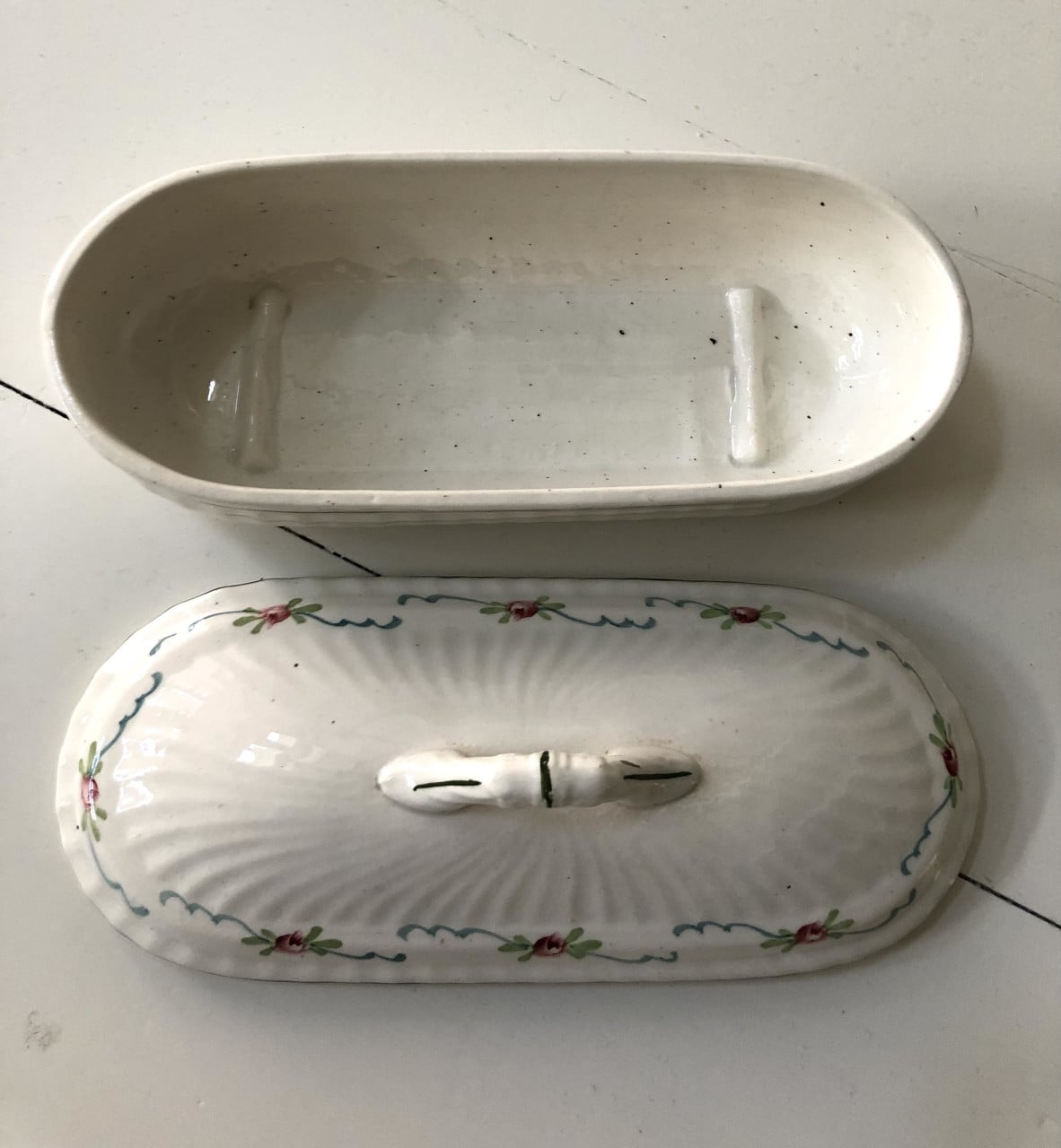 Lief brocante theelepelbakje van wit porselein met motiefje.