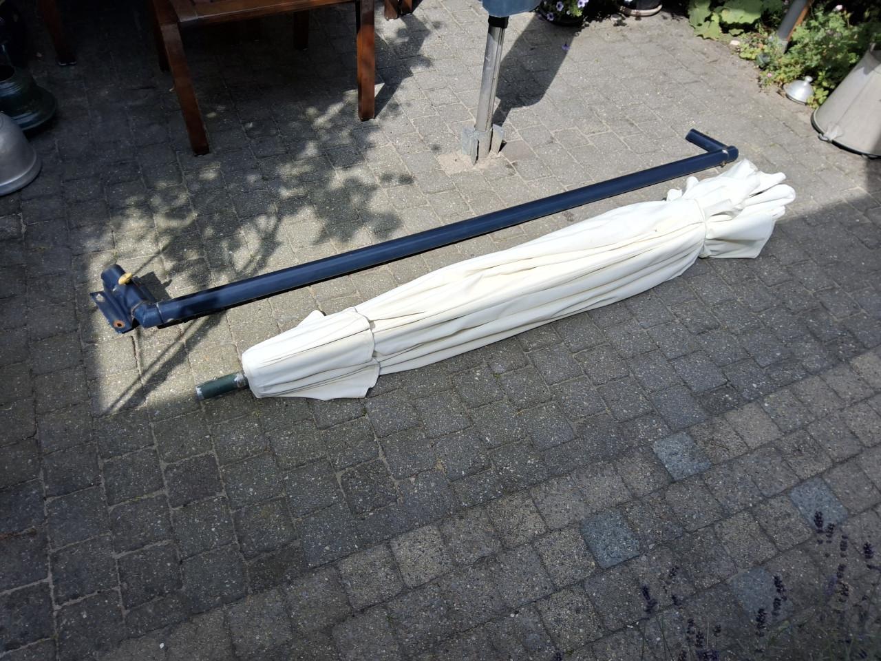 Tuin parasol met steun aan de muur.