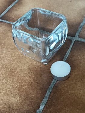 Glazen waxinelichthouder. Glas is onbeschadigd, dik en transparant.
