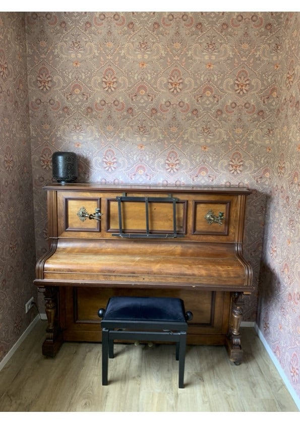 Oude bruine piano met kandelaren
