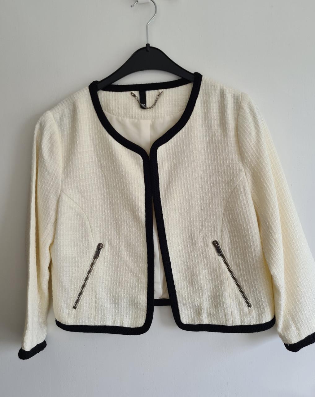 H&M bouclé jasje in de kleur room wit met zwarte bies. Maat 40