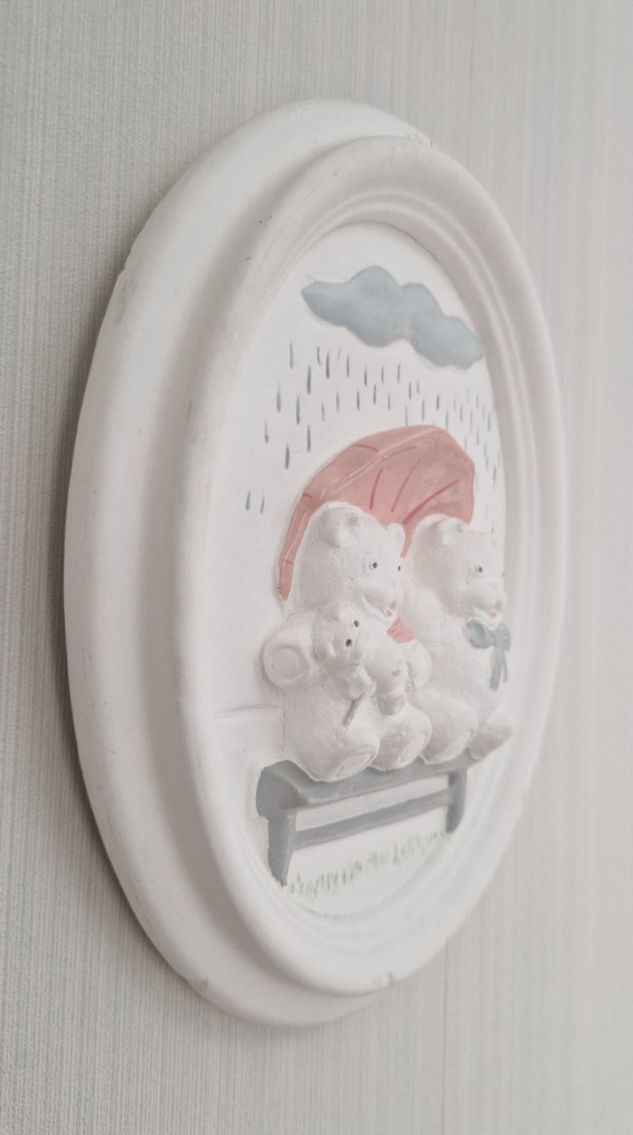 Schattige wanddecoratie van gips met 2 beertjes op een bankje in de regen