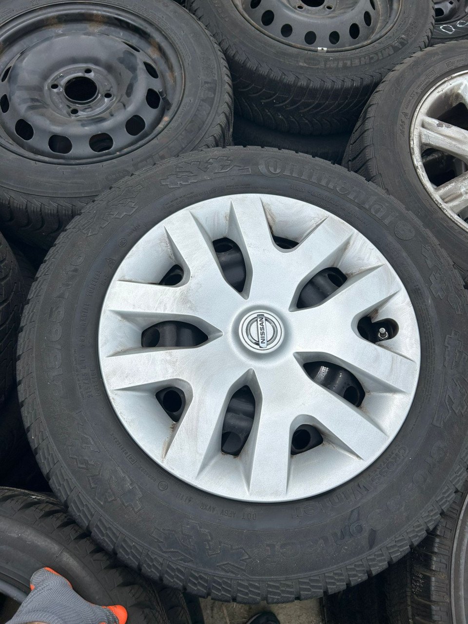 NISSAN STALEN VELGEN MET WIELDOPPEN EN CONTINENTAL CROSSCONTACT BANDEN '16'