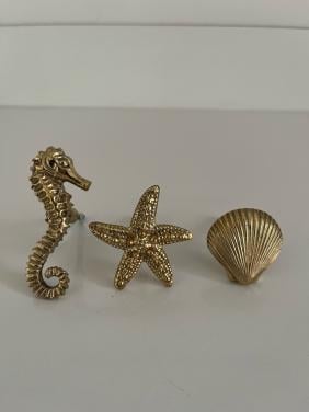 Gouden doing goods knoppen zeepaard links, schelp, zeester.