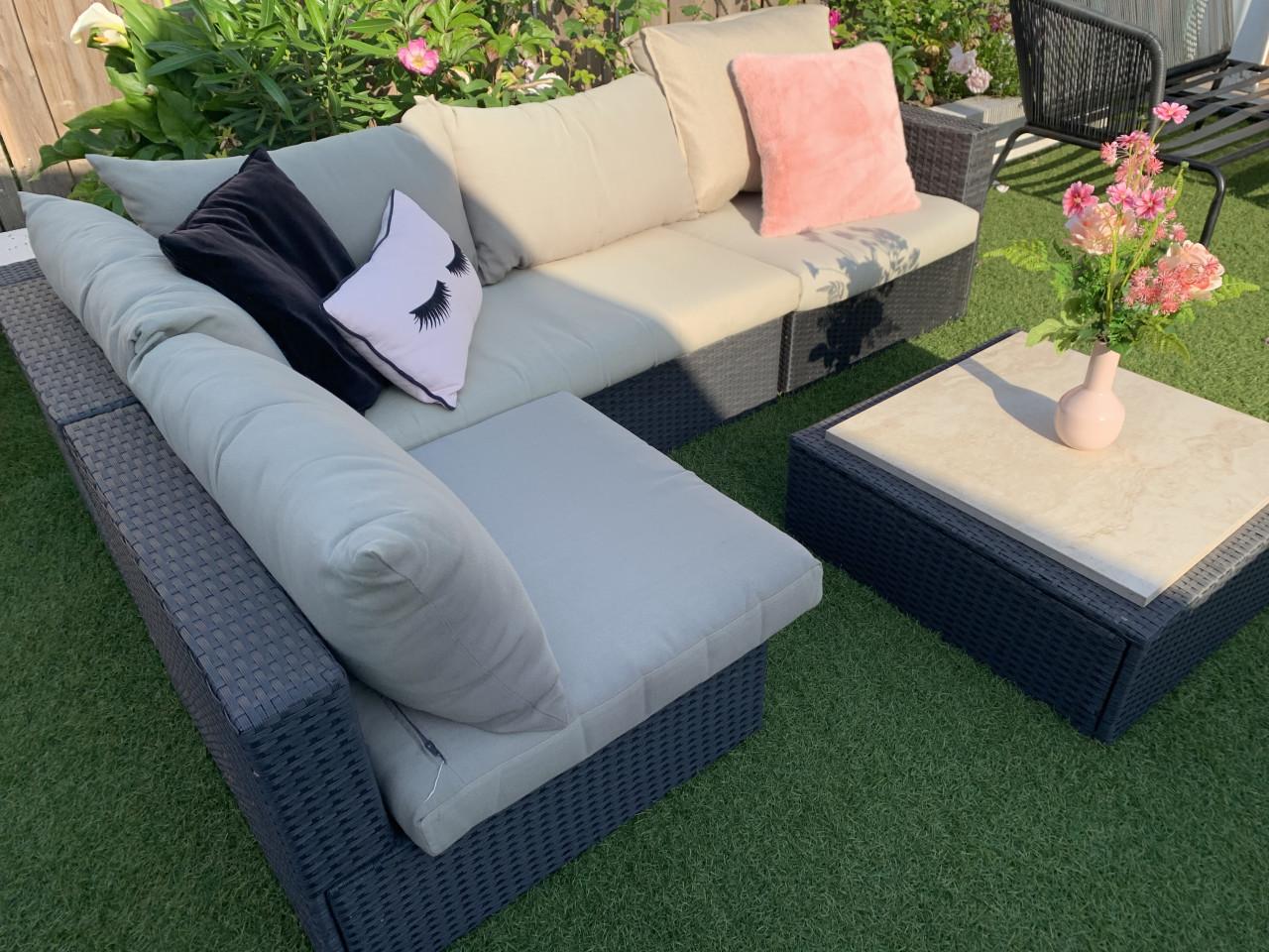 Wicker loungeset met kussens en tafel.
