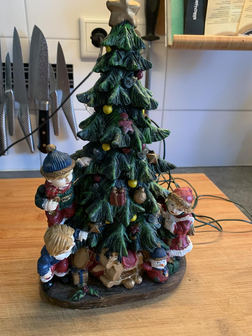 Verlichte keramieken kerstboom met kinderen